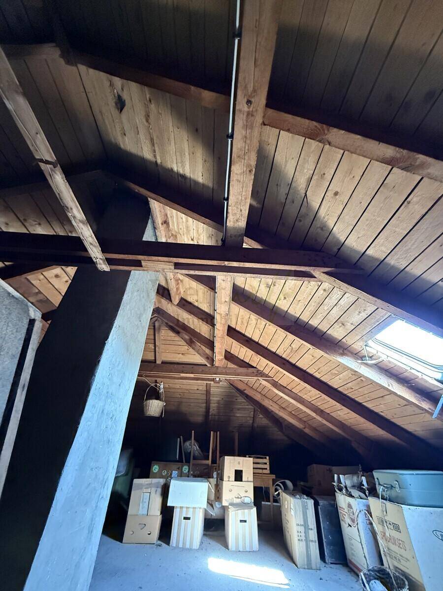 Geräumiger Dachboden mit Holzkonstruktion, Lagerflächen und einem Dachfenster.