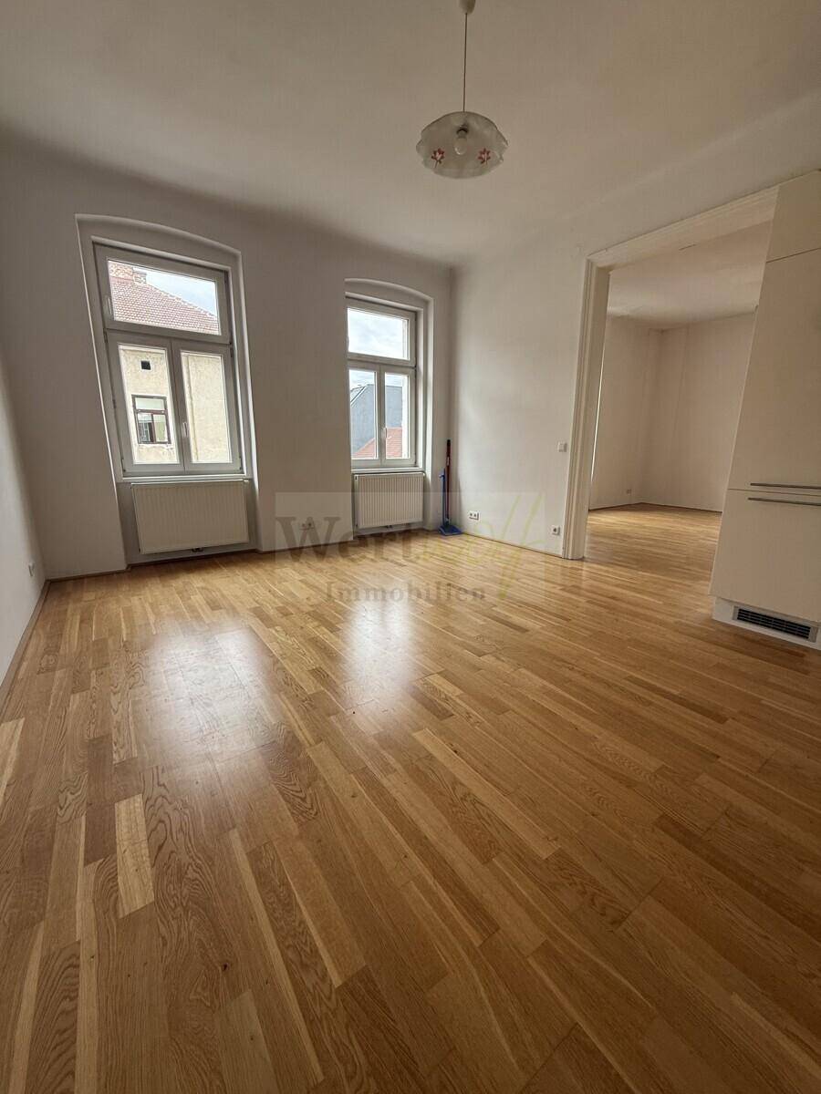 Geräumiges, helles Zimmer mit Parkettboden und zwei Fenstern, bereit zur individuellen Gestaltung.