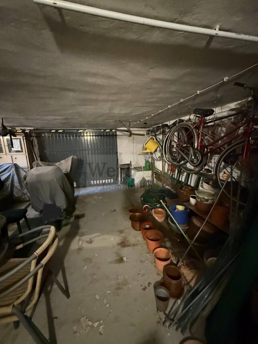 Geräumige Garage mit Betonboden, genutzt als Abstellraum für Fahrräder und Gartengeräte.