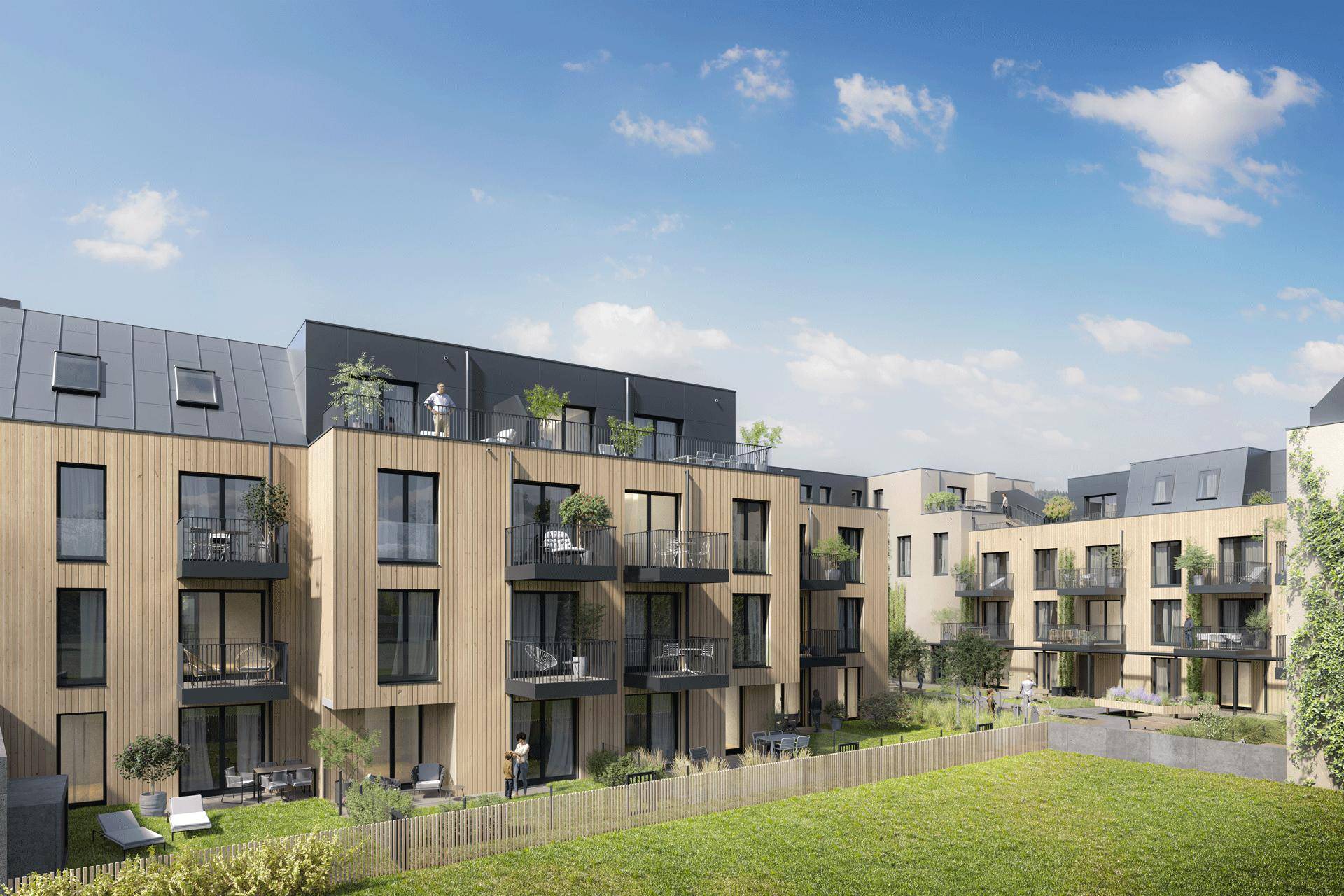 Moderne Wohngebäude mit Balkonen und einer großen Rasenfläche im Vordergrund für Erholung.