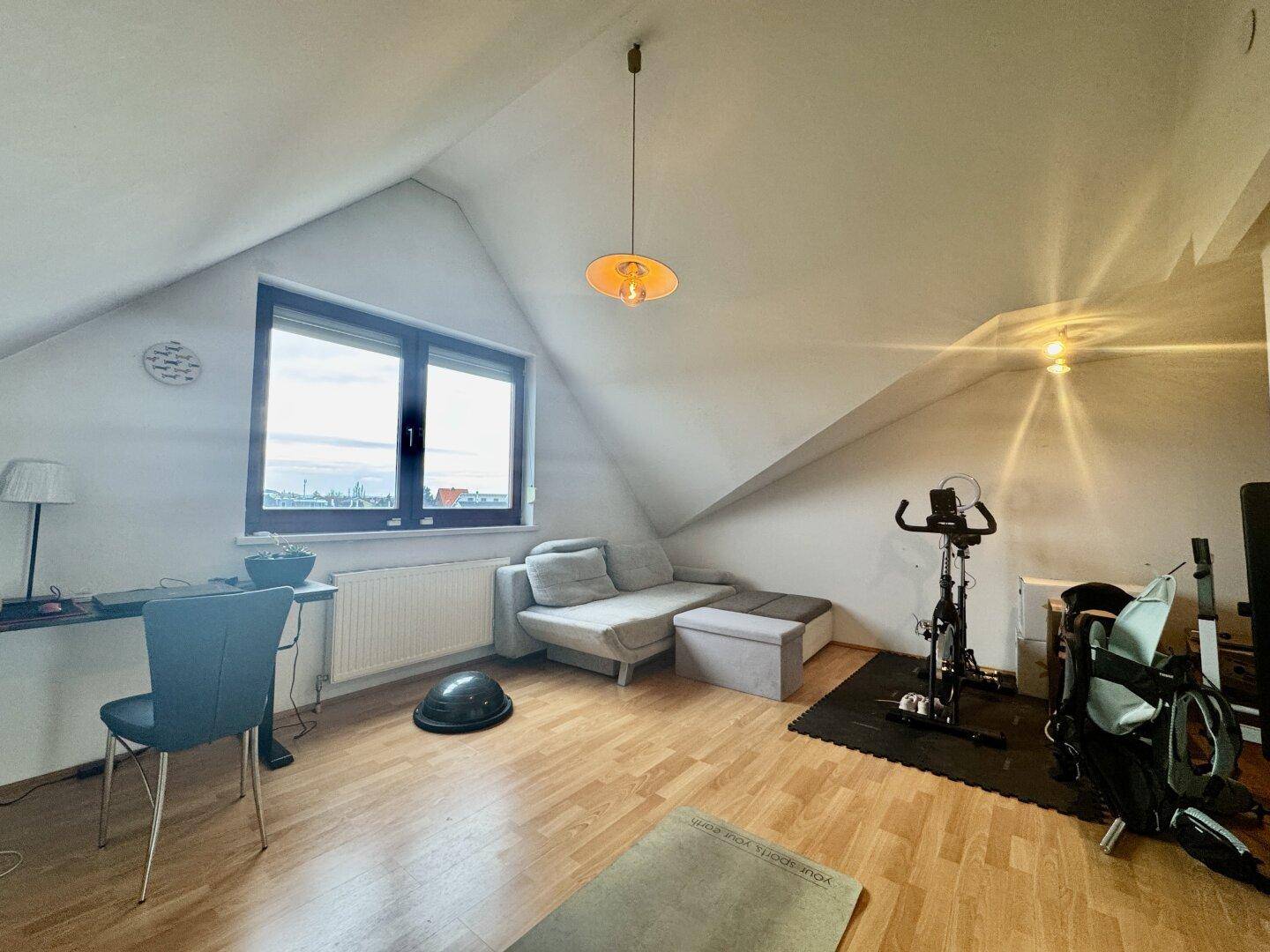 Ausgebautes Dachgeschoss mit schrägen Decken, als Fitness- und Entspannungsbereich genutzt.