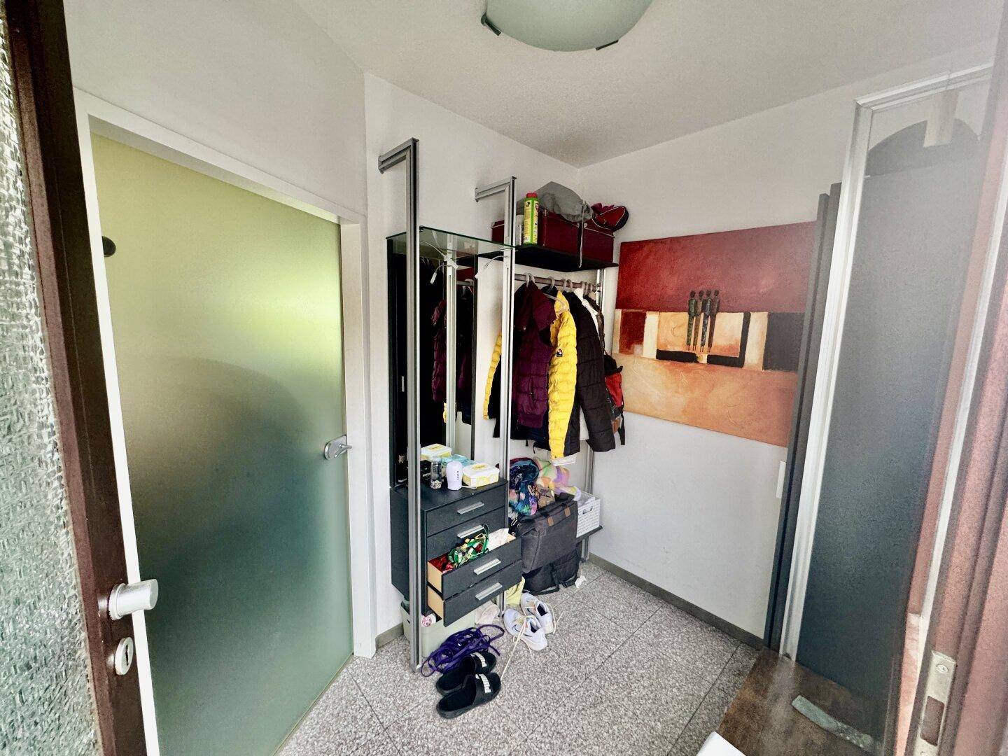 Kleiner Eingangsbereich mit Garderobe und Stauraum für Kleidung und Schuhe.