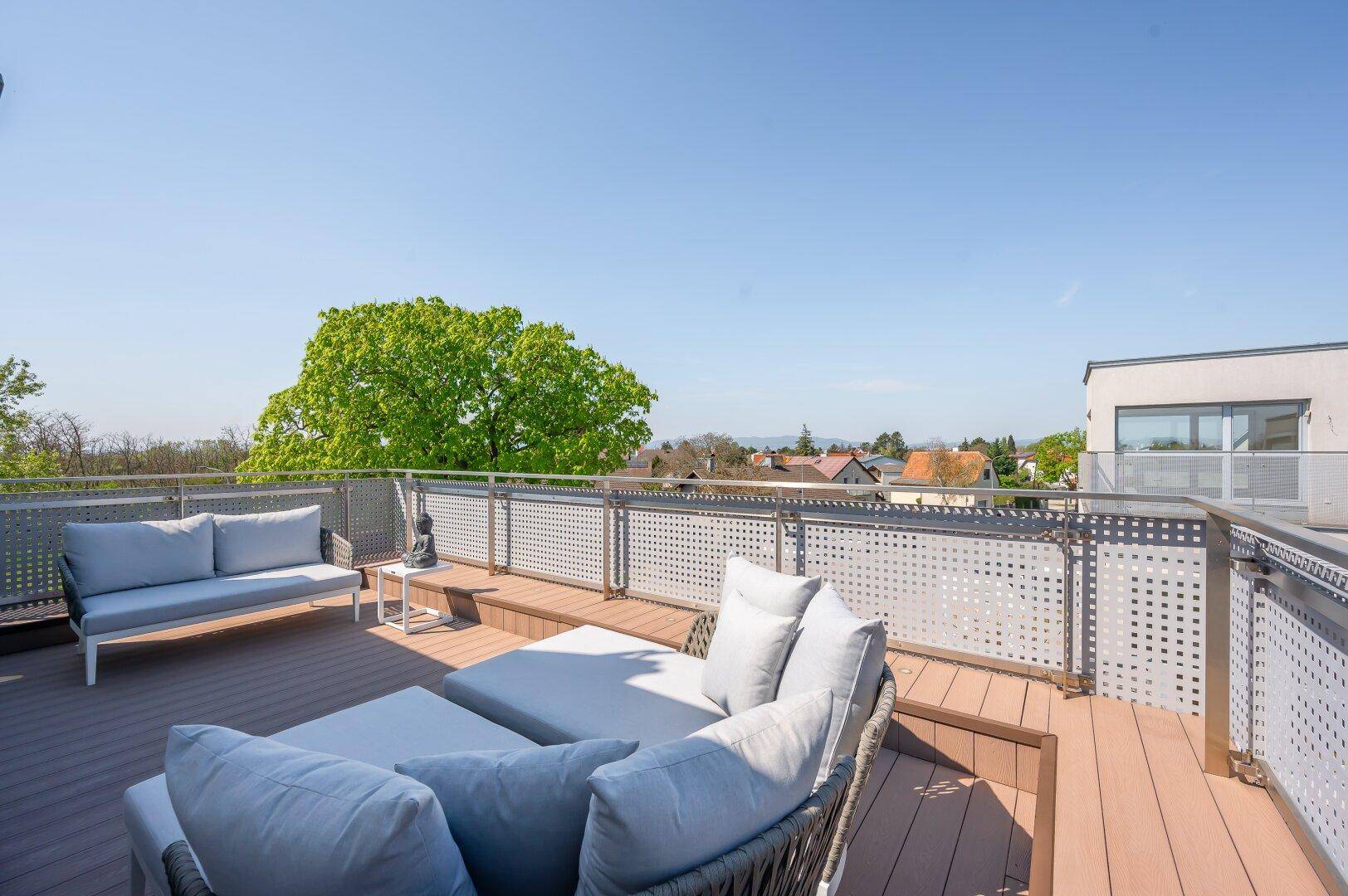 Geräumiger Balkon mit Lounge-Sofa und Panoramablick auf die umliegende Landschaft und Stadt.