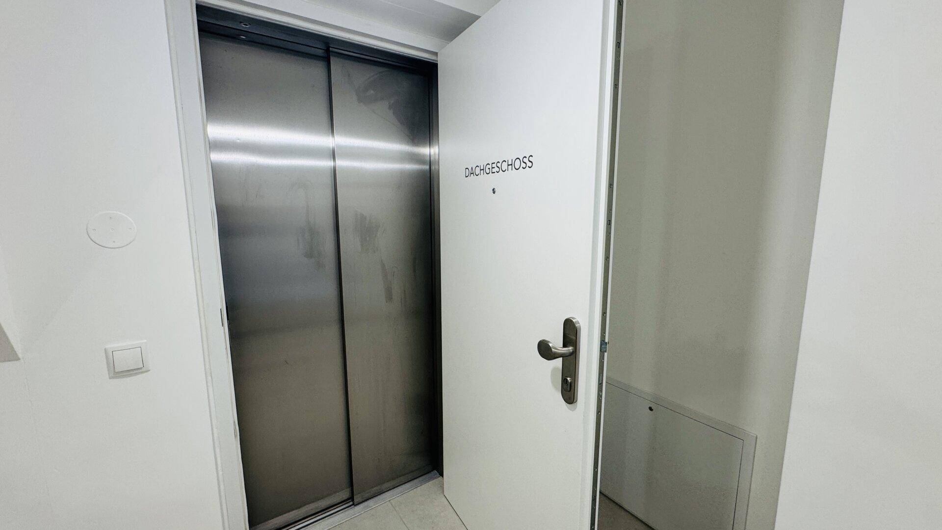 Moderner Aufzug im Treppenhaus, der das Dachgeschoss erschließt.