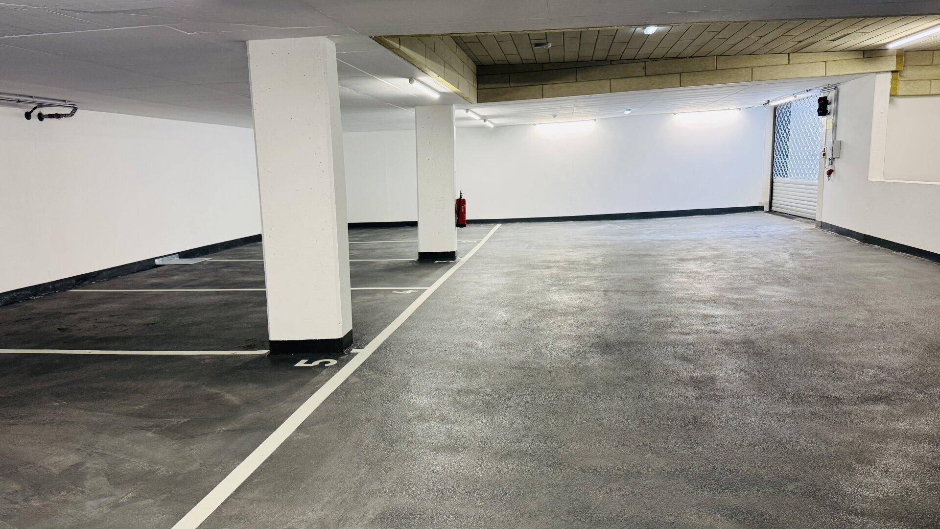 Geräumige Tiefgarage mit markierten Stellplätzen und guter Beleuchtung.