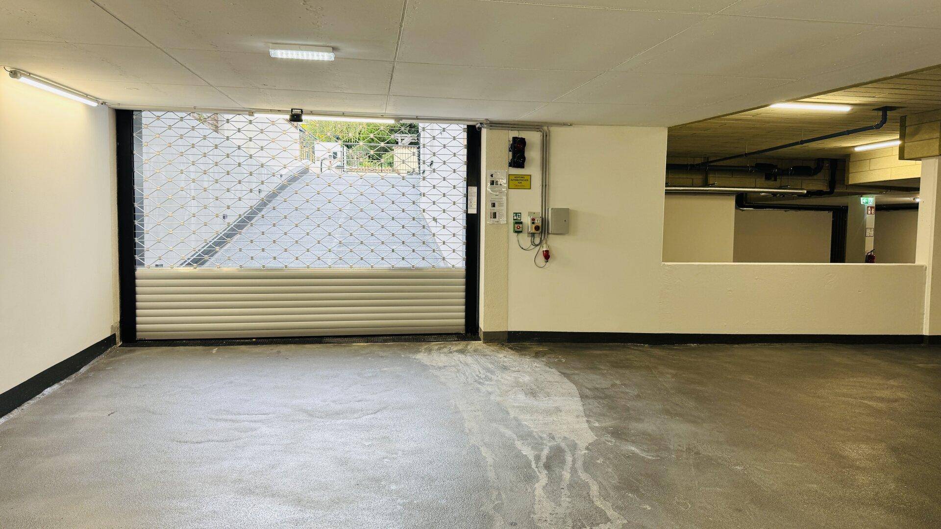Tiefgarage mit Rolltor und Zufahrt zur Straße.