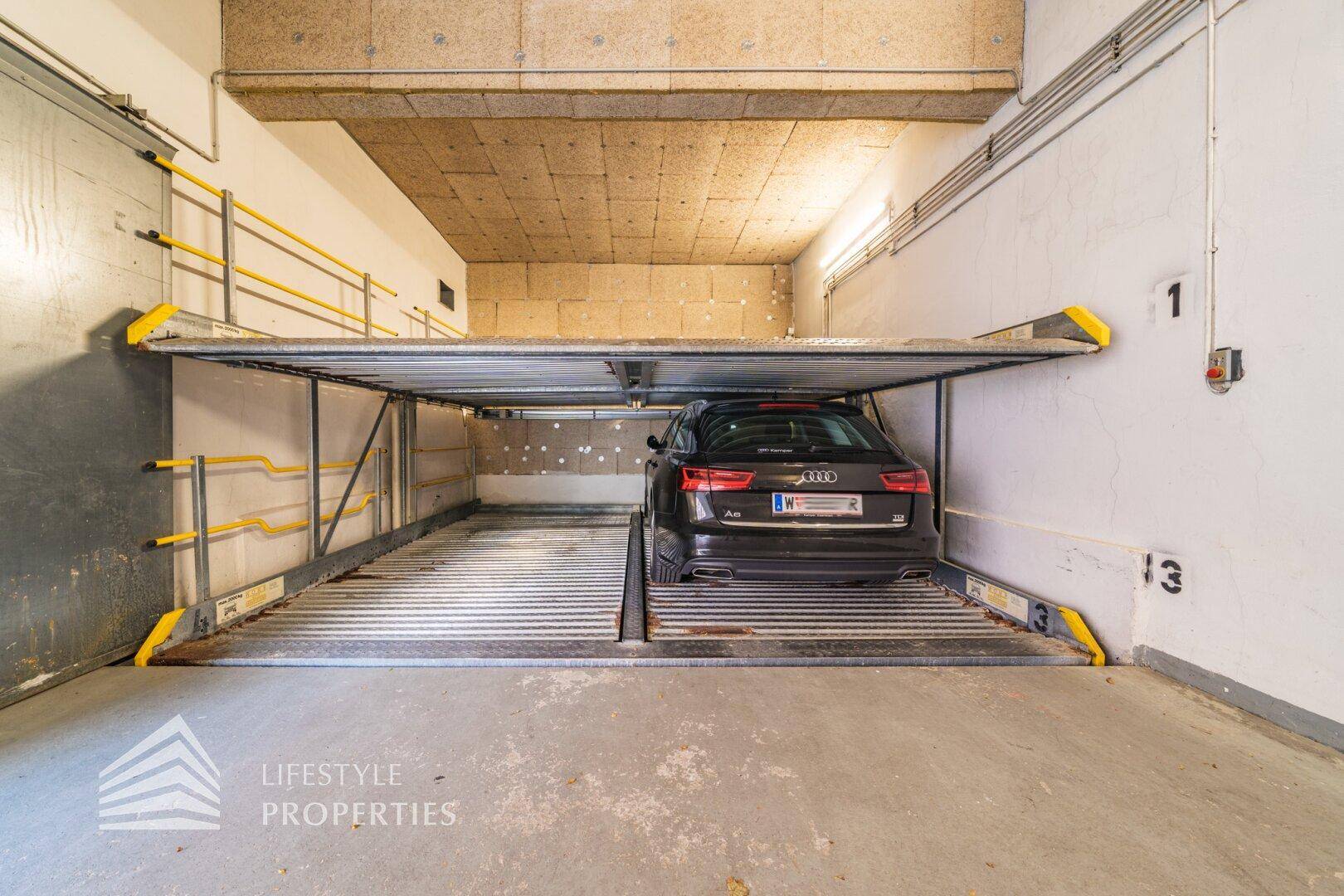 Detailansicht eines Stapelparkers in einer Tiefgarage, der ein Fahrzeug sicher auf einer oberen Ebene hält.