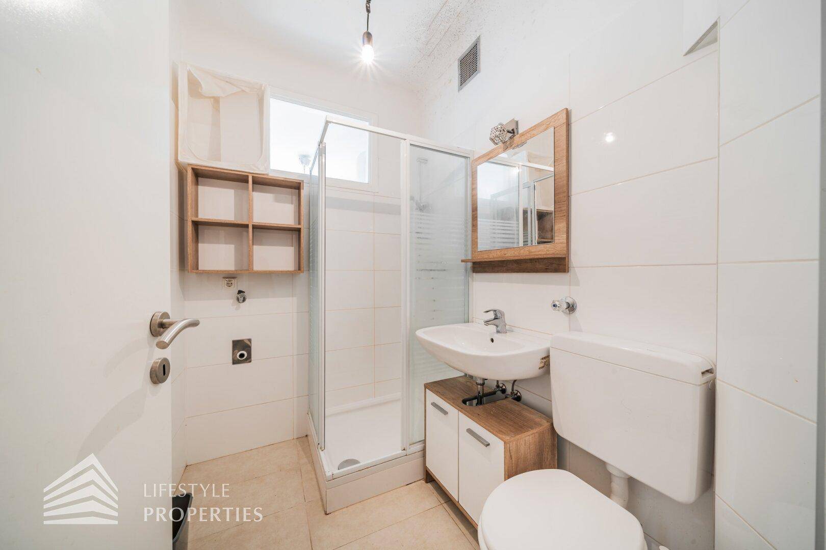 Modernes Badezimmer mit Duschkabine, Waschbecken und Spiegel.