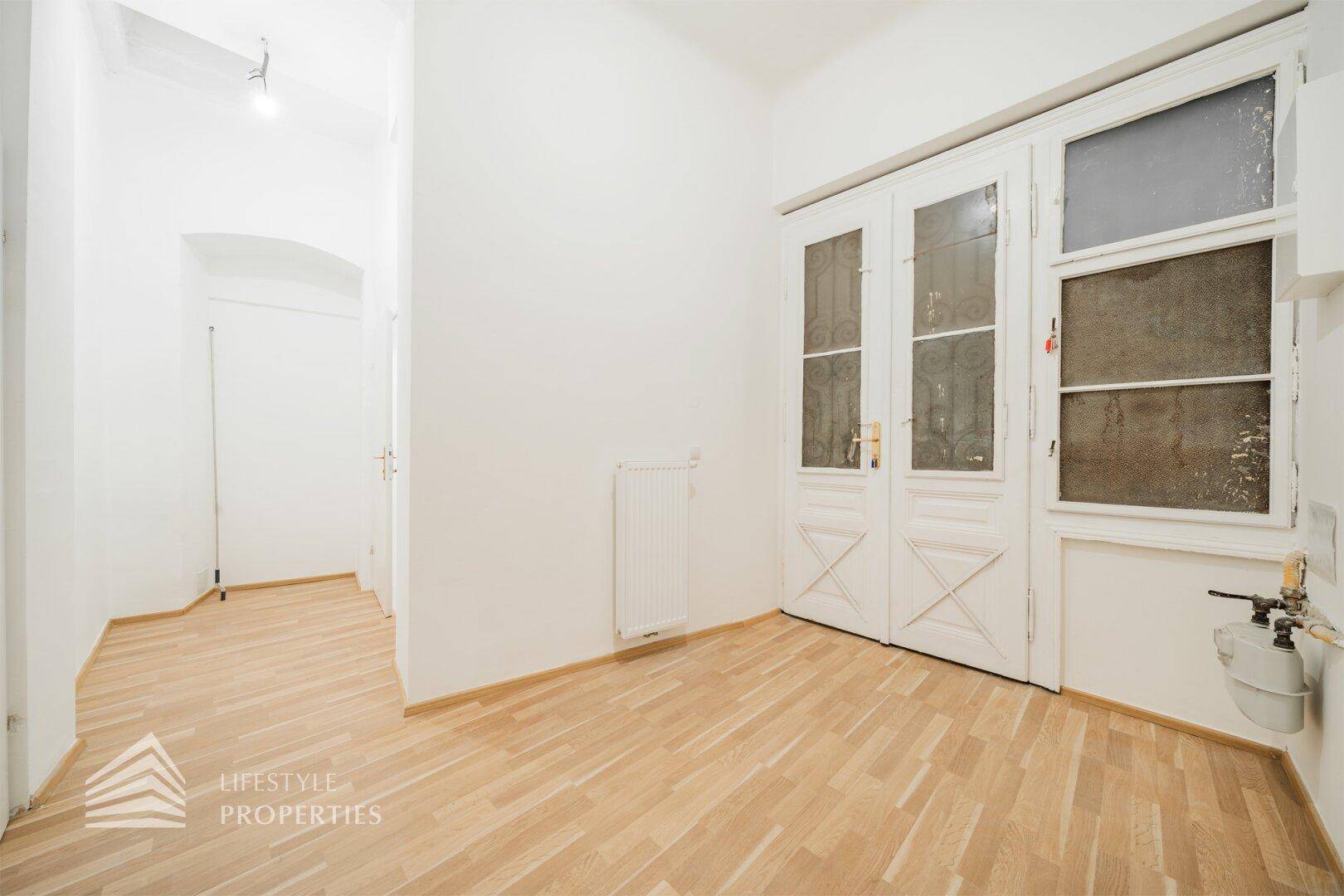 Heller Raum mit Holzboden und charmanten, alten Doppeltüren mit Glaseinsätzen.