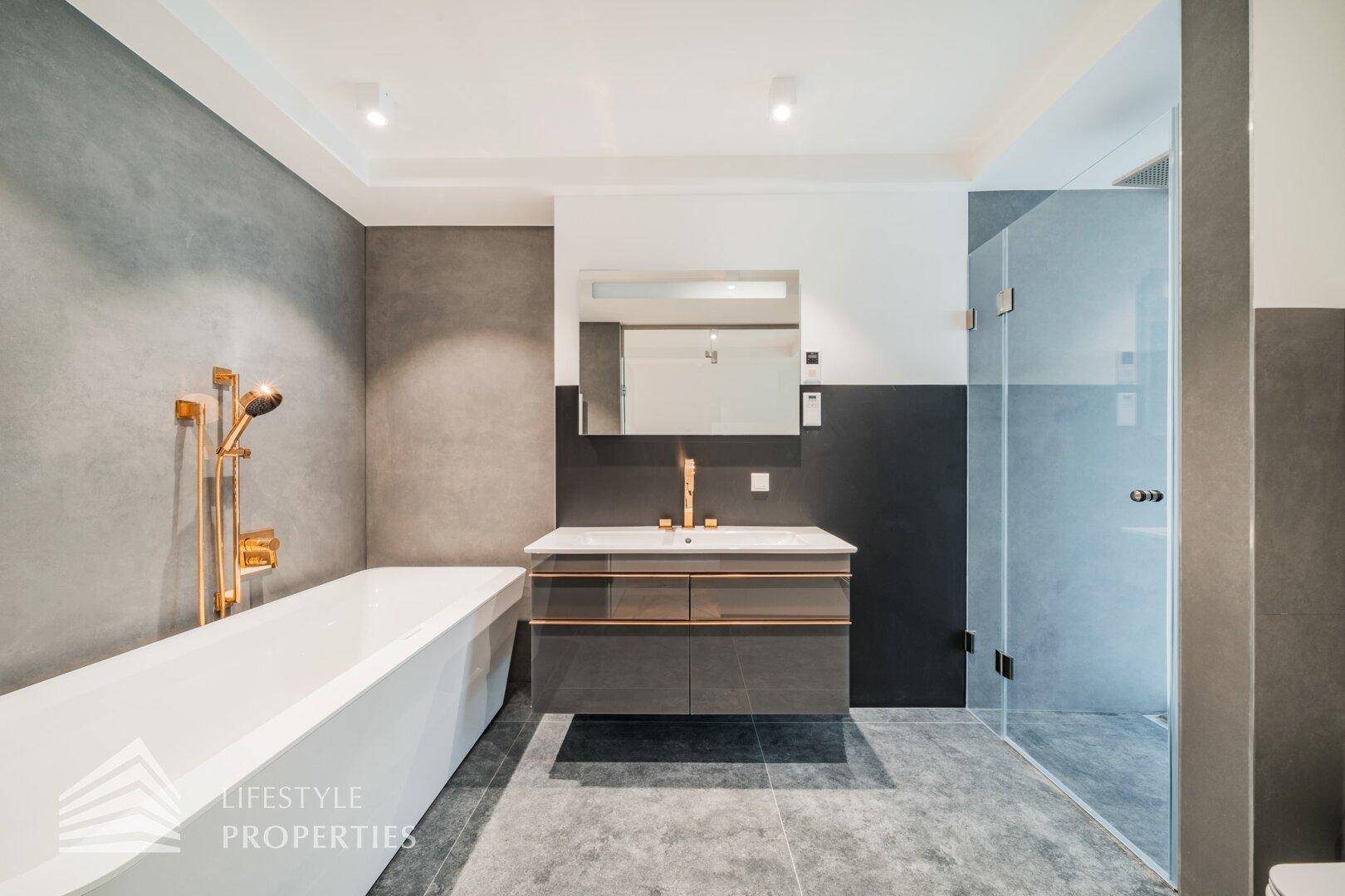 Elegantes Badezimmer mit freistehender Badewanne, begehbarer Dusche und modernen Armaturen in Roségold.