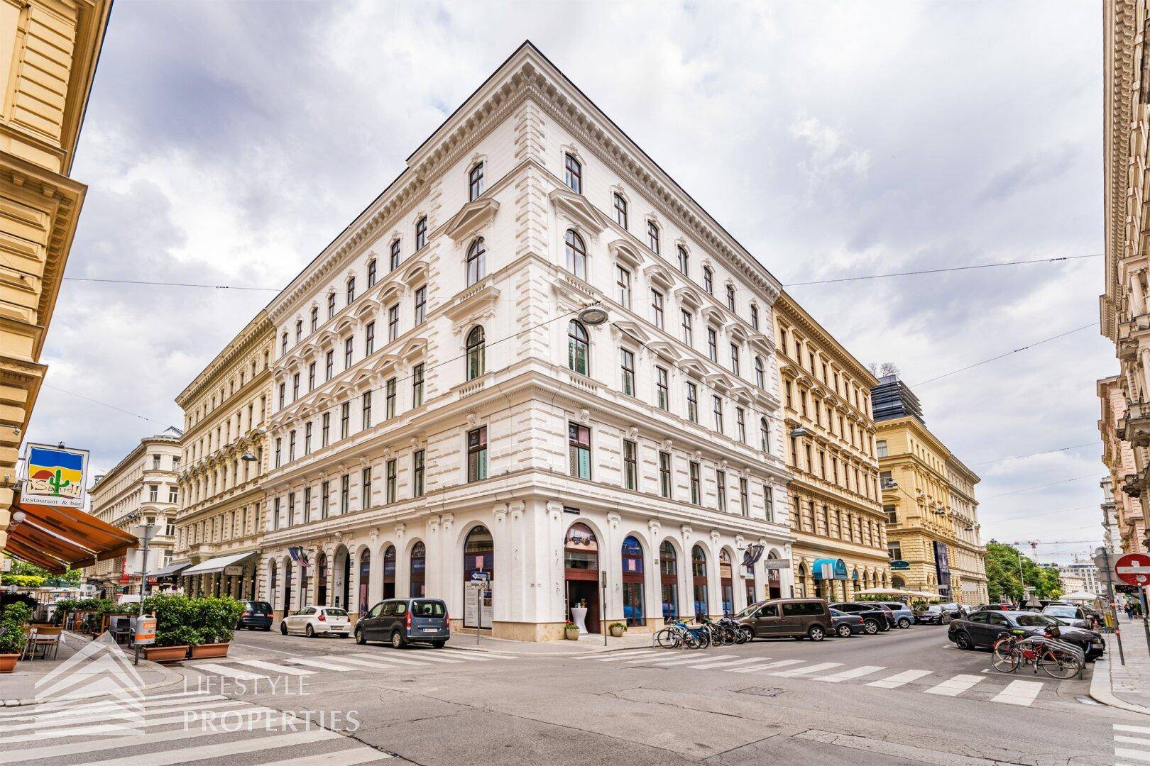 Prächtiges Eckgebäude mit klassischer Architektur in einer belebten Stadtstraße.