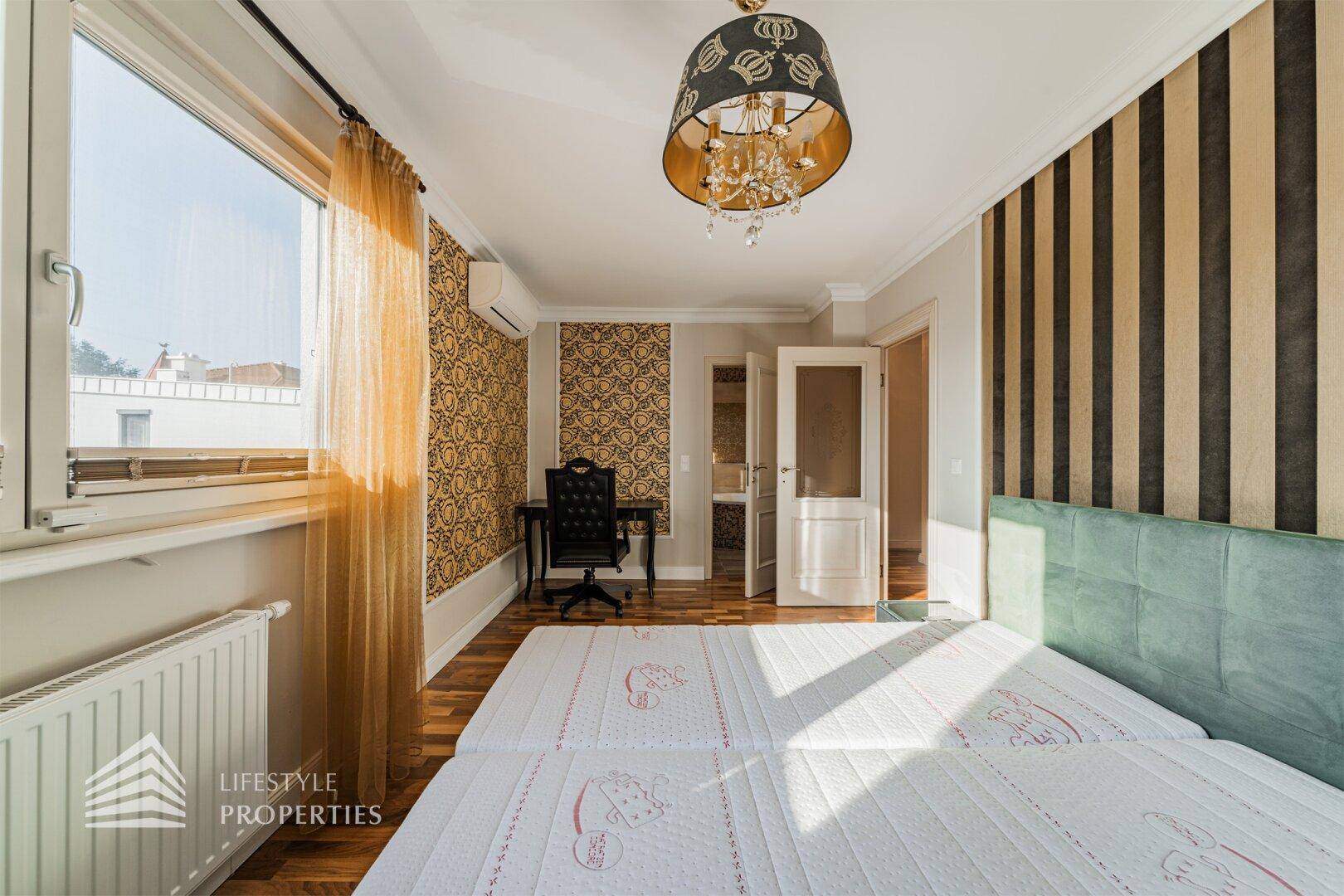 Helles Schlafzimmer mit Doppelbett, Schreibtisch und gemusterten Wänden in elegantem Design.