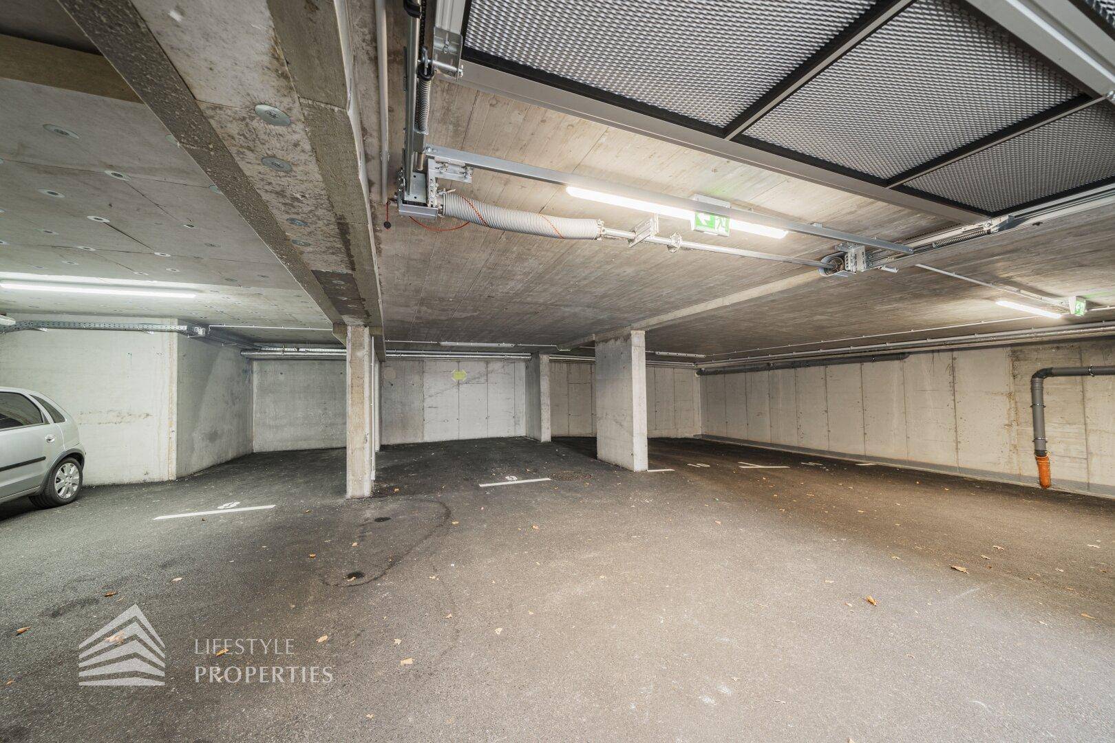 Tiefgarage mit Betonwänden und -decken, ausreichend Platz für mehrere Fahrzeuge.