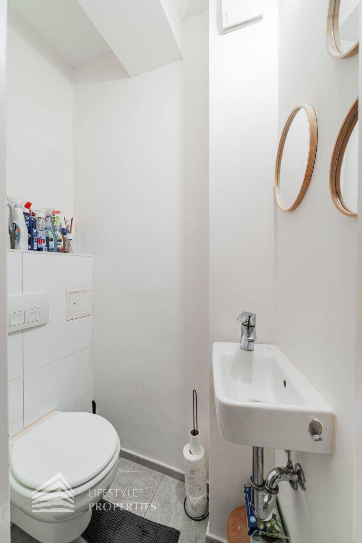 Kleines Gäste-WC mit wandhängender Toilette und kompaktem Handwaschbecken.