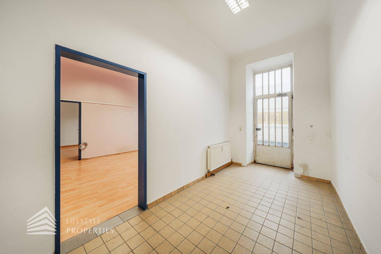 Kleinerer Raum mit Fliesenboden und einem Fenster mit Gitter, ideal für Lager oder Nebenräume.