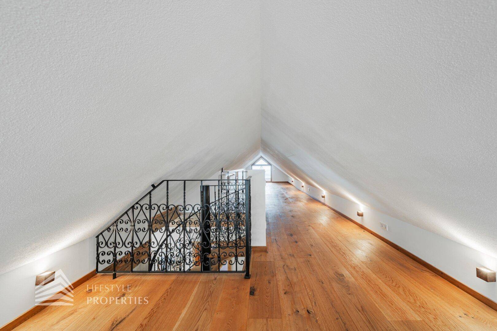 Ausgebauter Dachboden mit Holzboden und Dachschräge, bietet vielseitige Nutzungsmöglichkeiten.