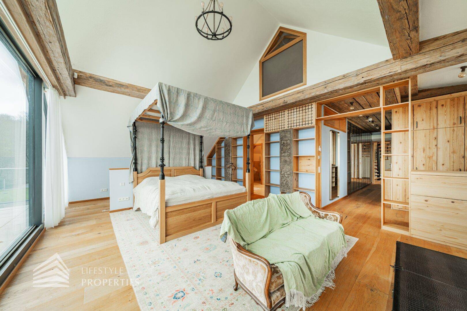Geräumiges Schlafzimmer mit Holzbalken, Himmelbett und integrierten Holzregalen.
