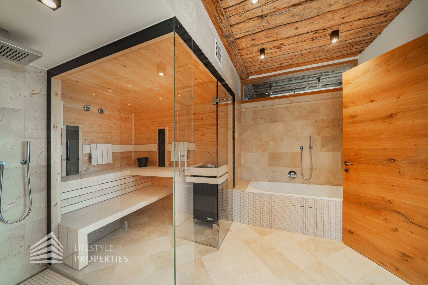 Geräumiges Badezimmer mit integrierter Sauna, Dusche und Badewanne unter Holzdecke.