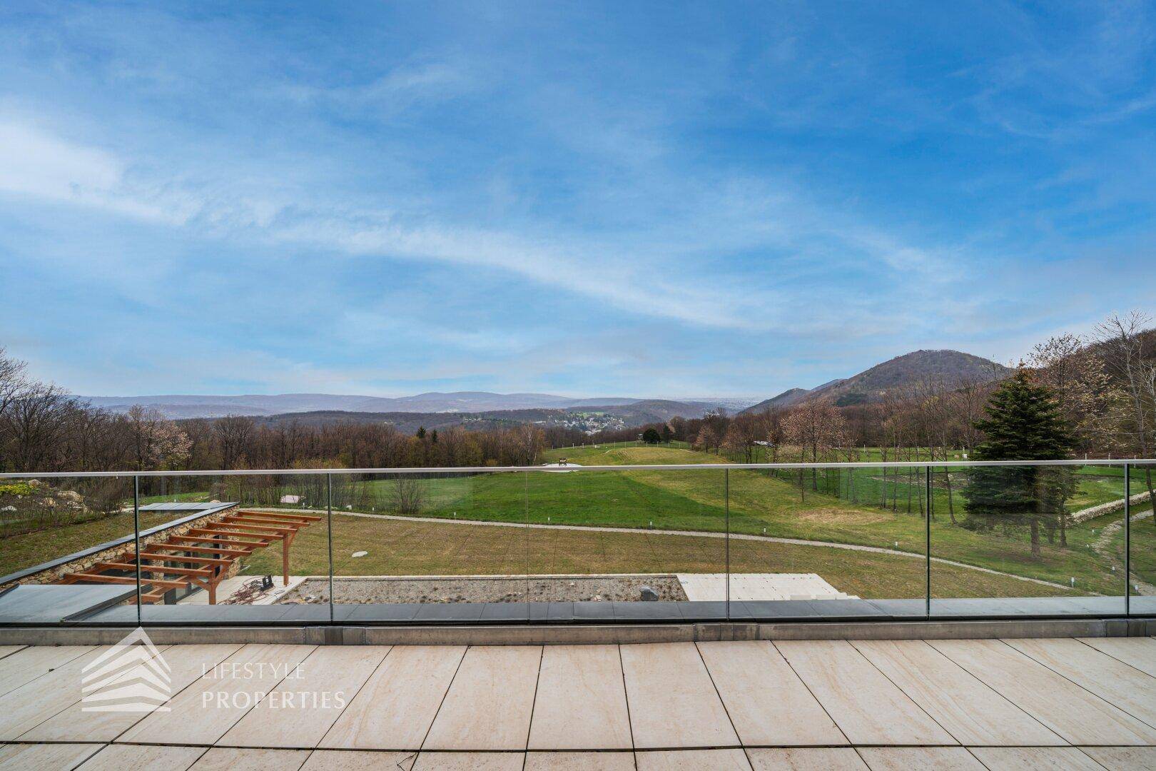 Panoramablick von der oberen Terrasse auf die weite Landschaft und die umliegenden Wälder.