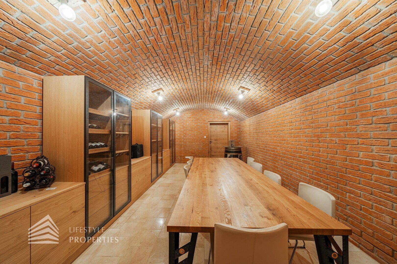 Rustikaler Essbereich mit Ziegelgewölbedecke, langem Holztisch und Weinschränken.