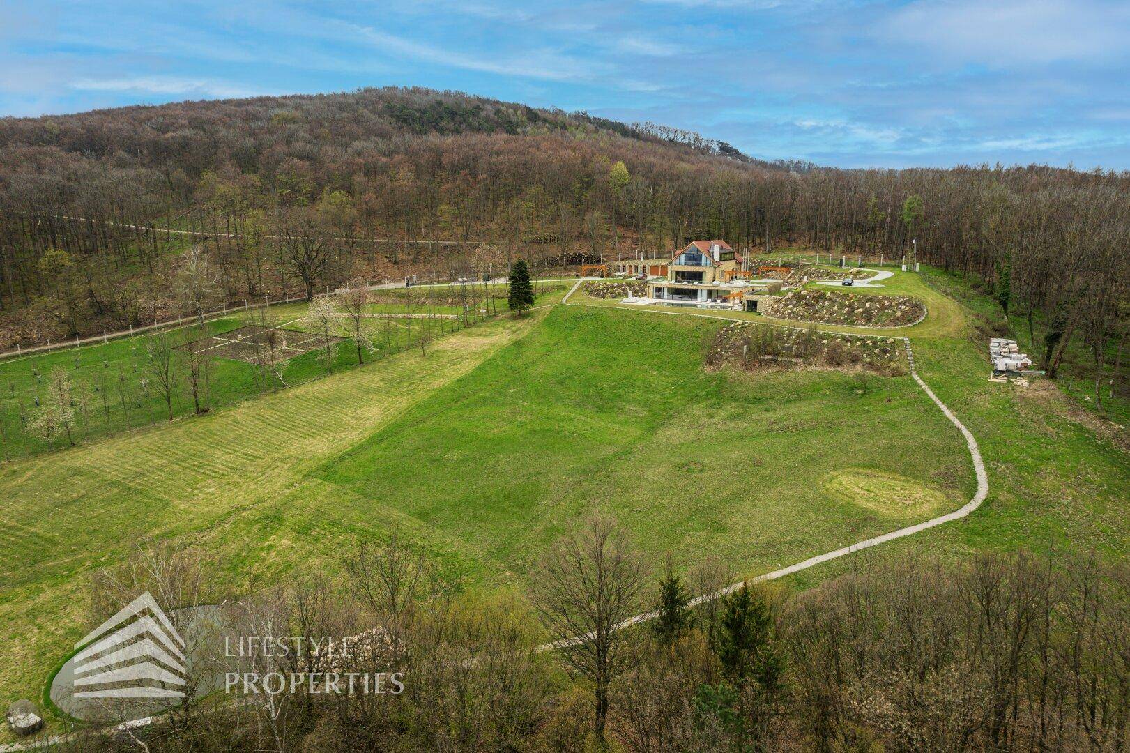 Panoramische Luftaufnahme des luxuriösen Anwesens, eingebettet in eine weitläufige Naturlandschaft.