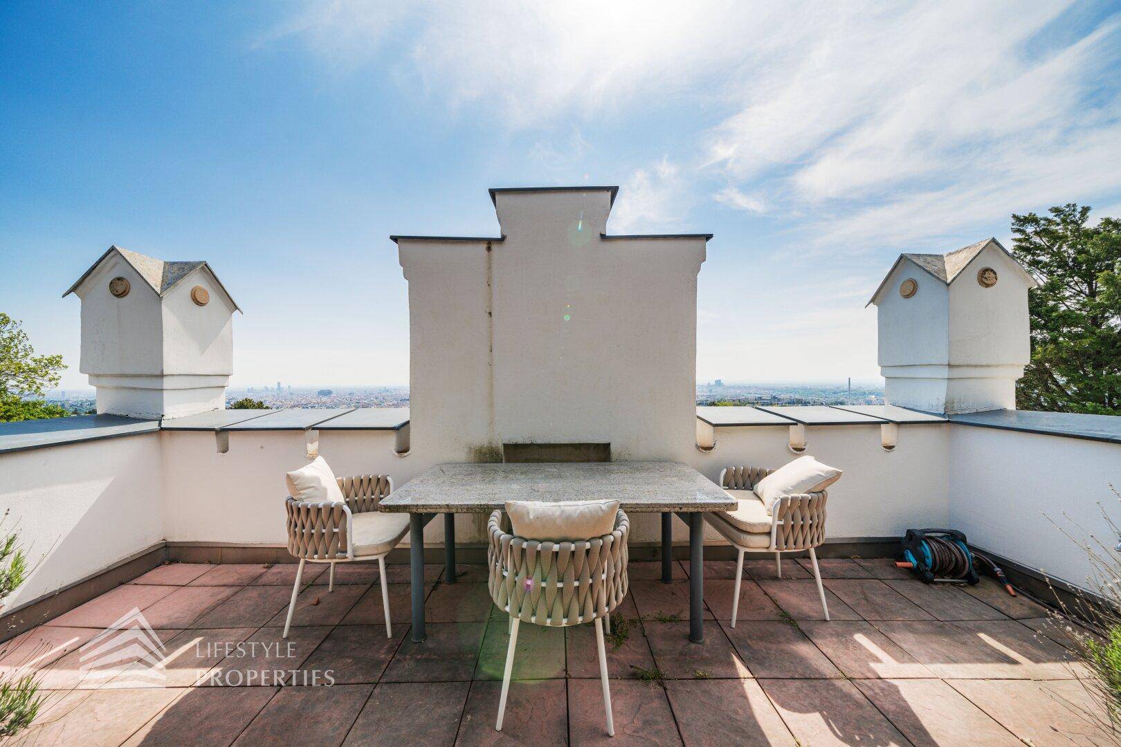 Möblierte Dachterrasse mit Esstisch und Panoramablick über die Umgebung.