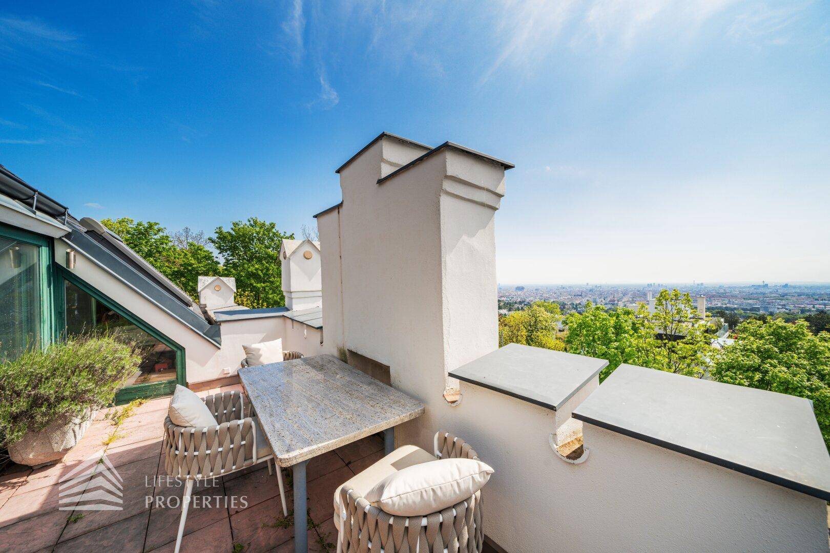 Sonnenterrasse mit Sitzgelegenheiten und weitem Blick über die Stadt.