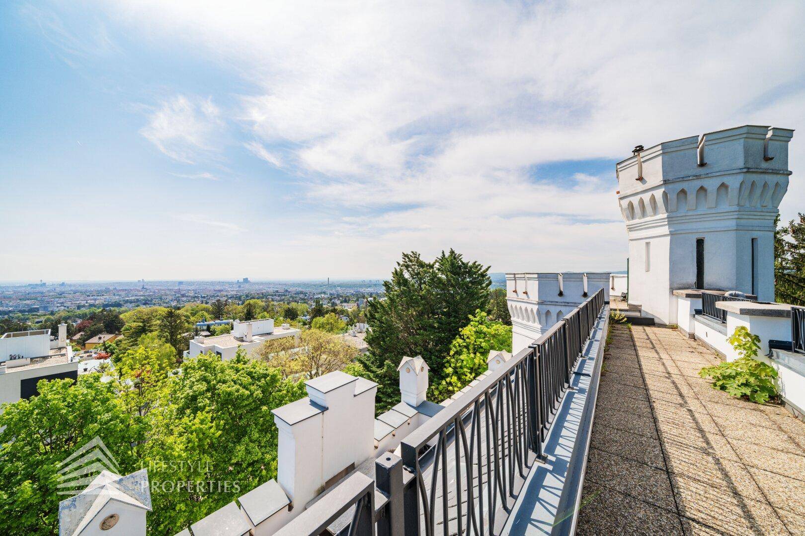 Lange Terrasse mit Zinnen und weitem Blick über die Stadt und die bewaldete Umgebung.