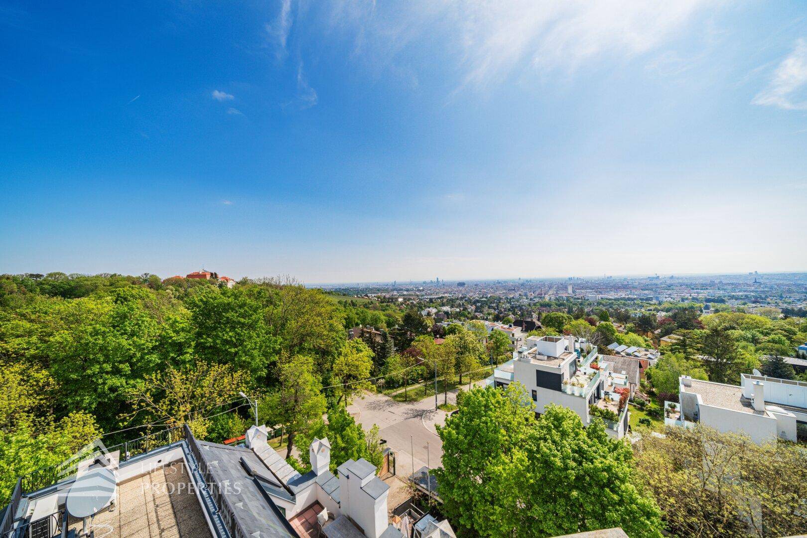 Panoramablick von der Dachterrasse über die Stadt und die weite, grüne Landschaft.