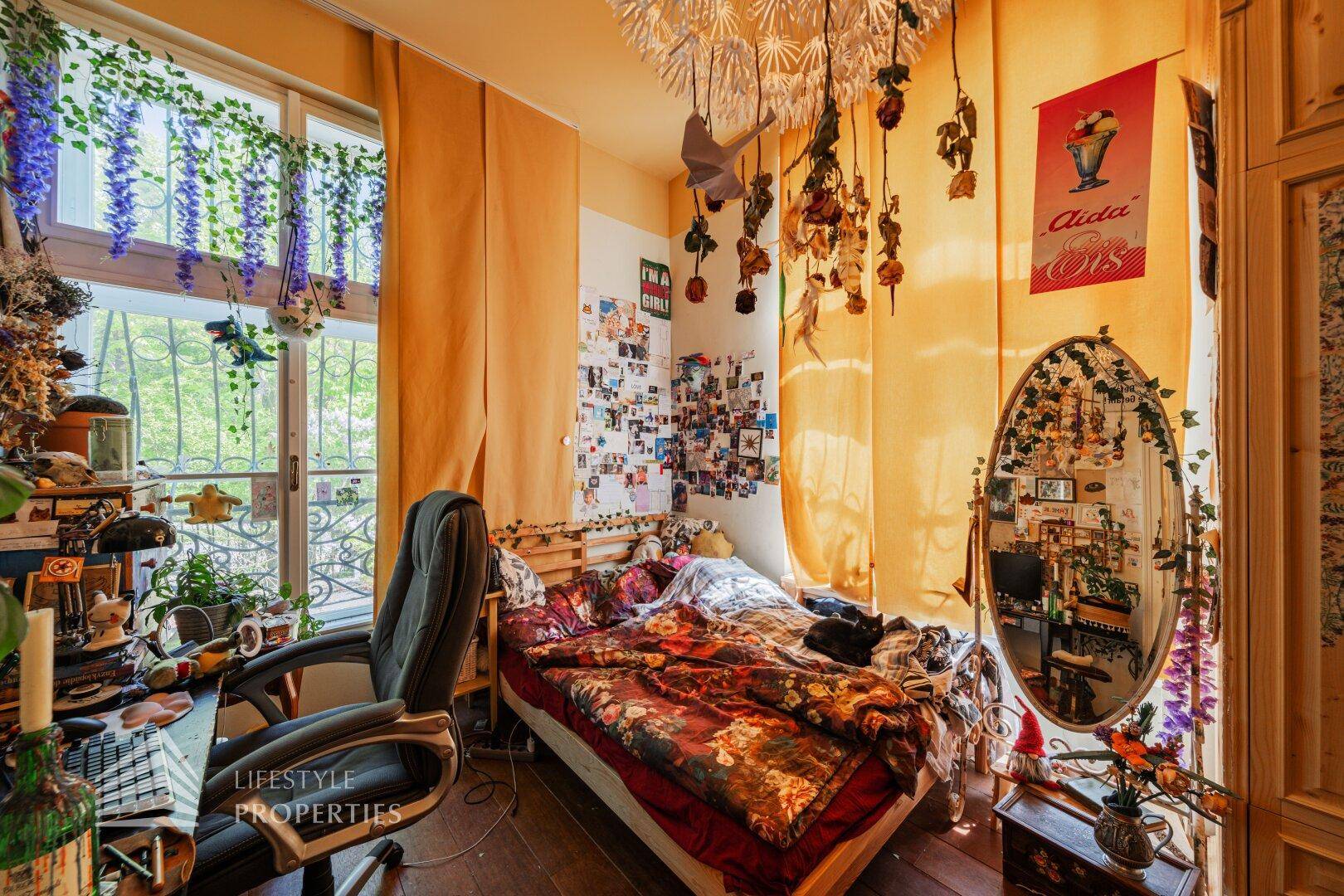 Helles Schlafzimmer mit Balkonzugang, Holzboden und individueller Dekoration.