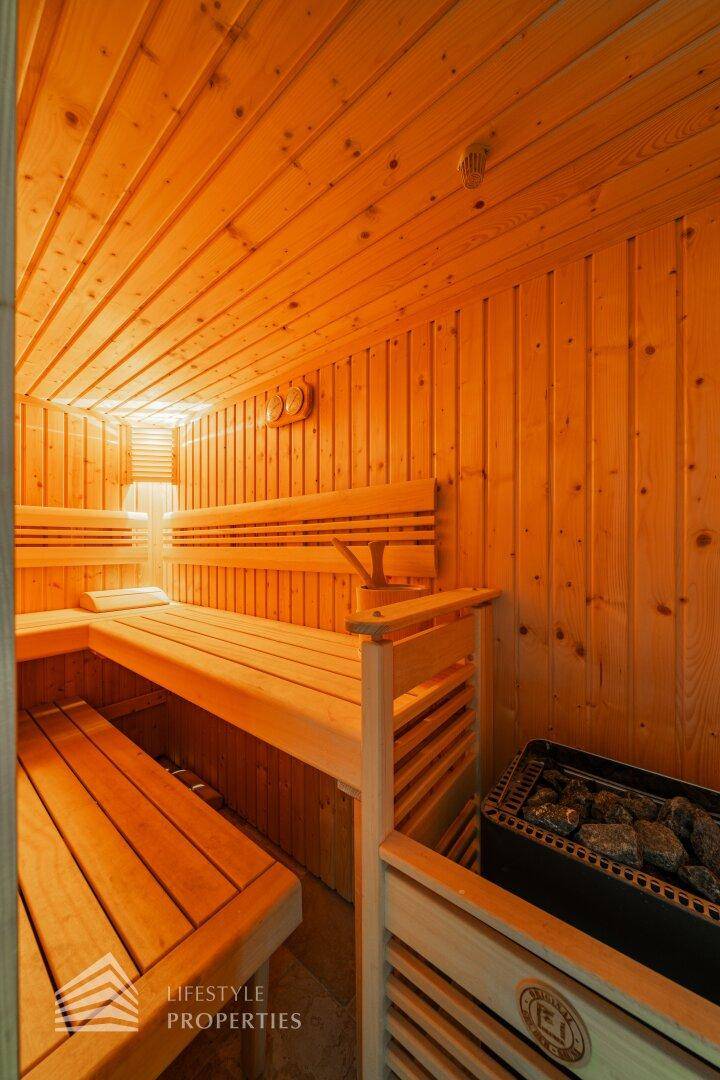 Holzvertäfelte Sauna mit mehreren Bänken und Saunaofen für Entspannung.