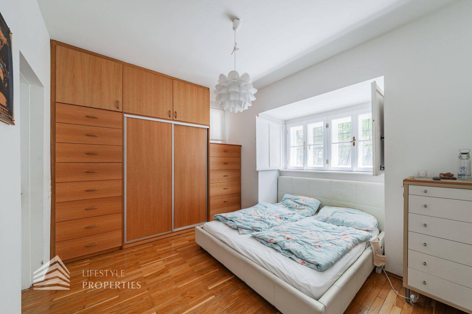 Helles Schlafzimmer mit großen Einbauschränken und Holzboden.