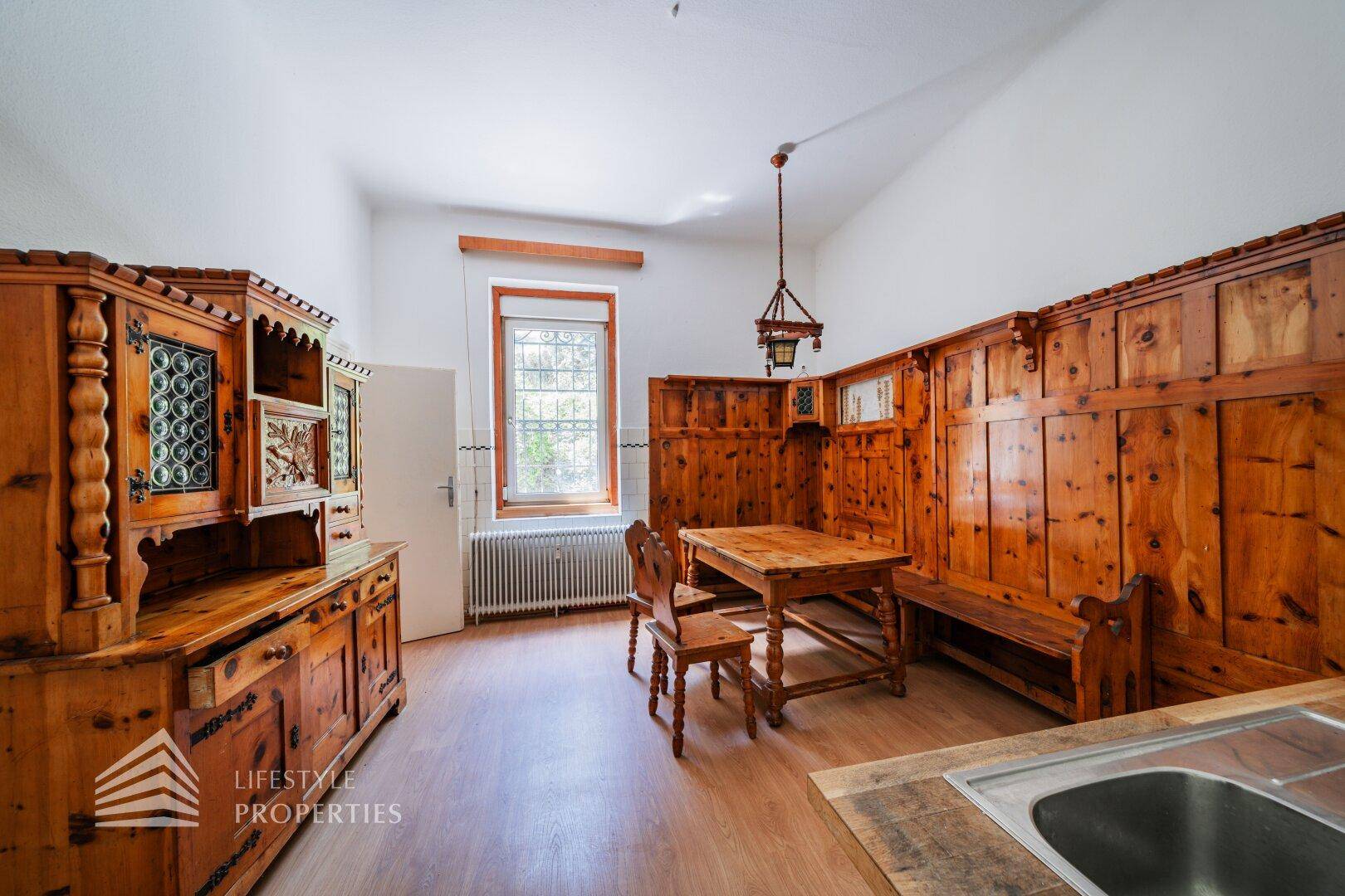 Traditioneller Essbereich mit Holztäfelung, rustikalen Möbeln und Fenster.