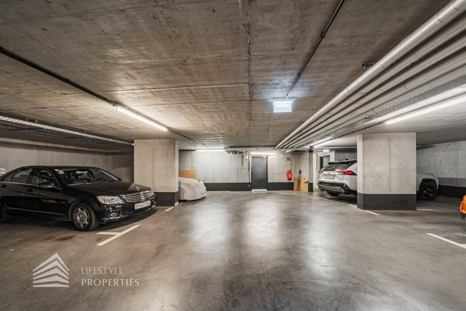 Geräumige Tiefgarage mit mehreren Stellplätzen und Betonwänden.