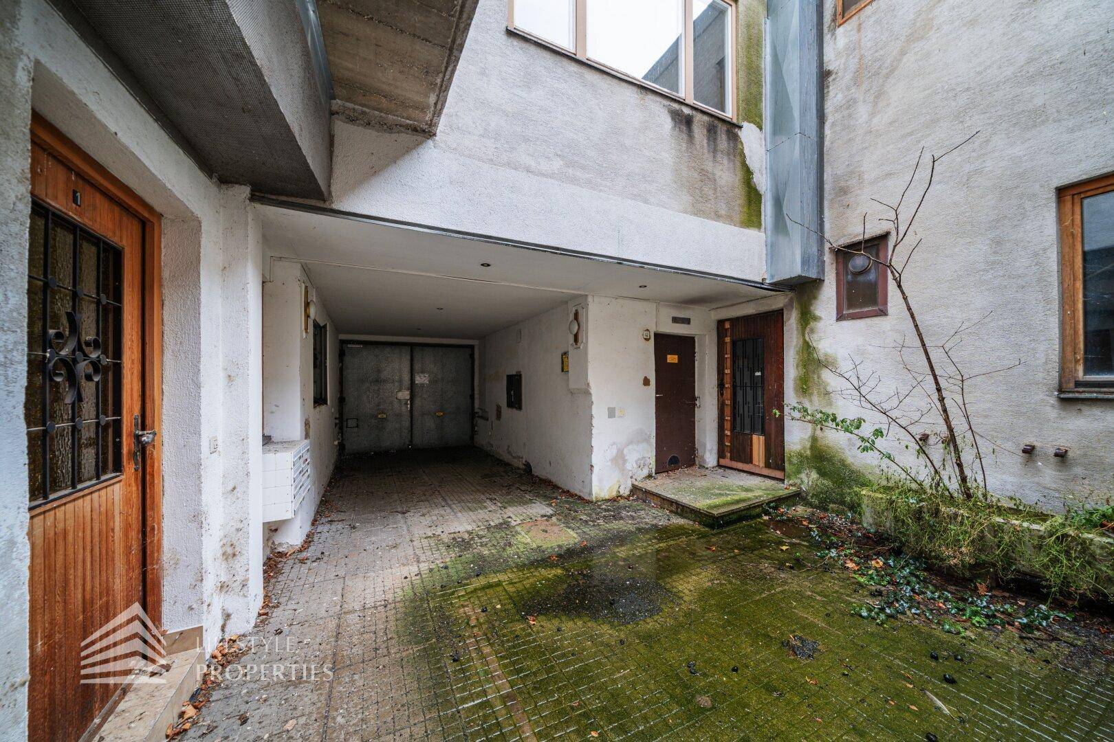 Innenhof mit mehreren Eingängen und einem Garagenbereich.