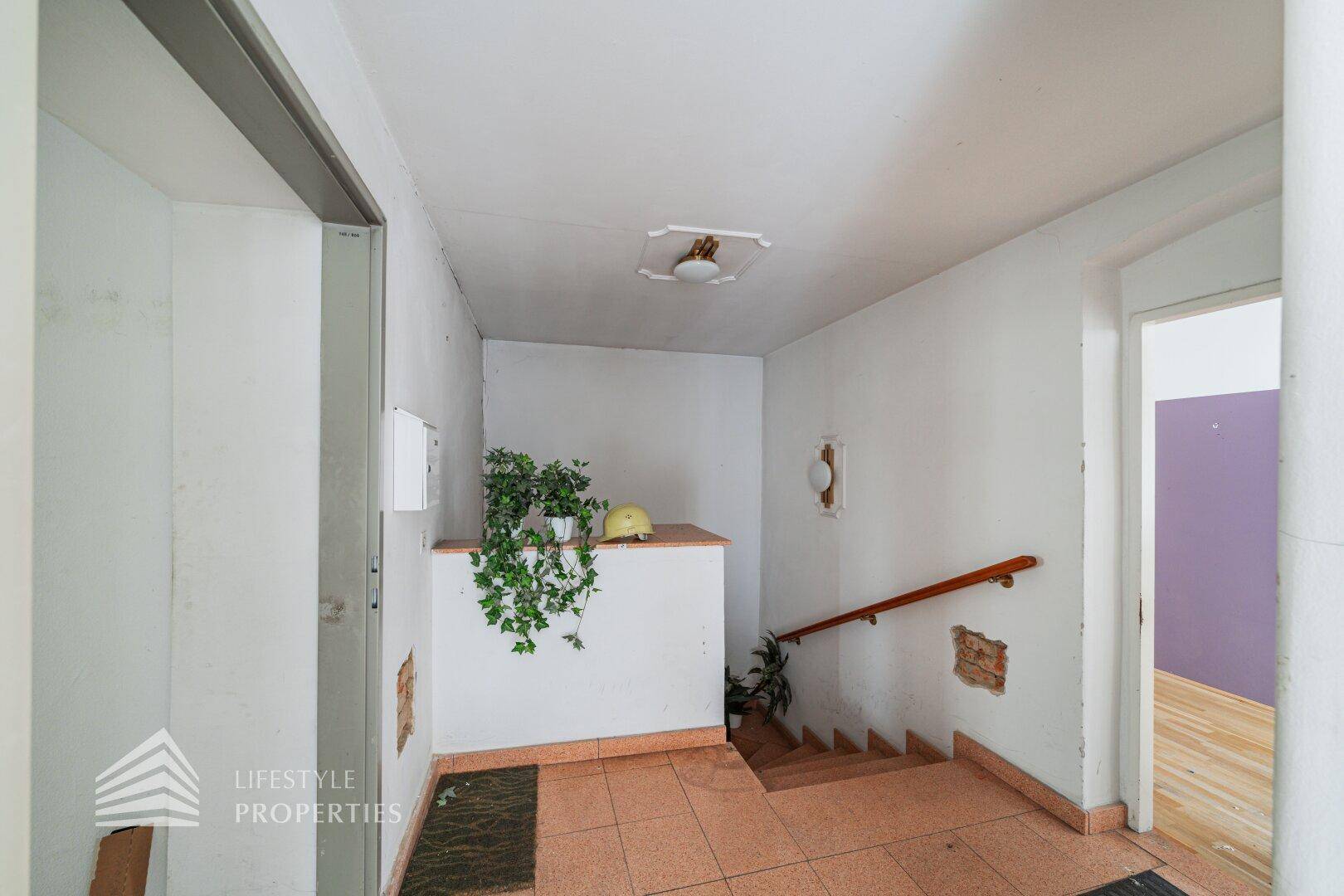 Eingangsbereich mit Treppe, Fliesenboden und einfacher Gestaltung.