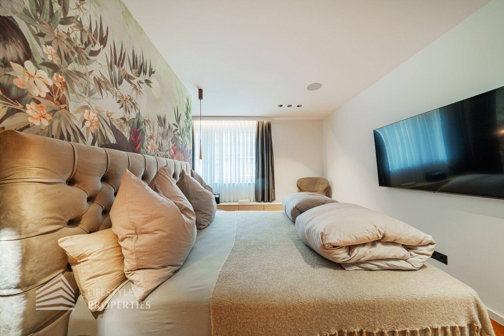 Gemütliches Schlafzimmer mit großem Bett, floraler Tapete und integriertem Fernseher.