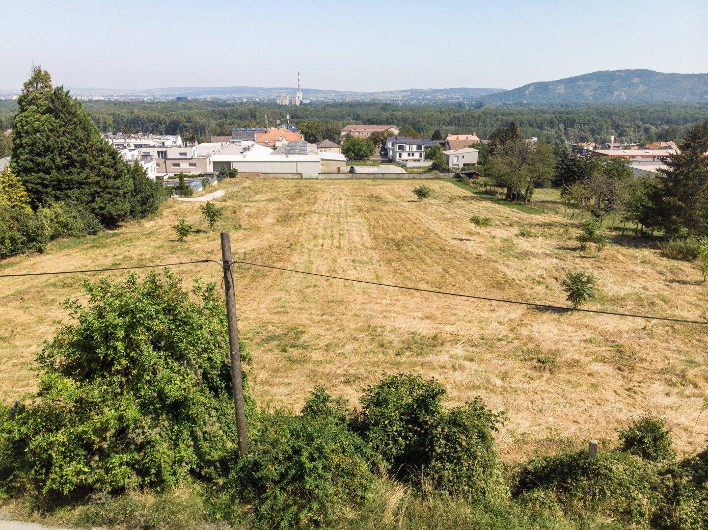 Luftaufnahme des Grundstücks mit Blick auf die weite Landschaft und eine Stadt in der Ferne.