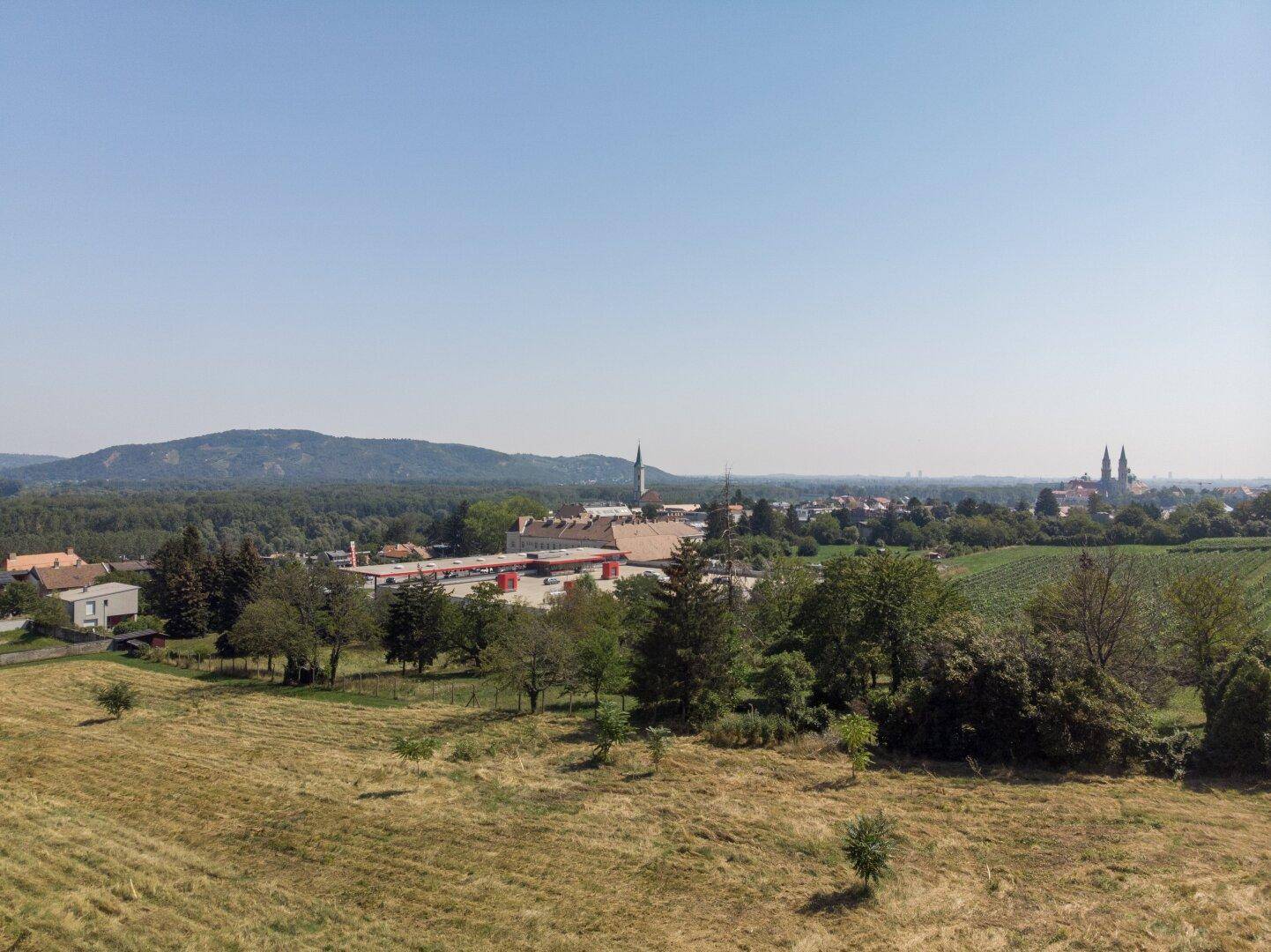 Panoramablick vom Grundstück auf die weite Landschaft und die Stadt am Horizont.