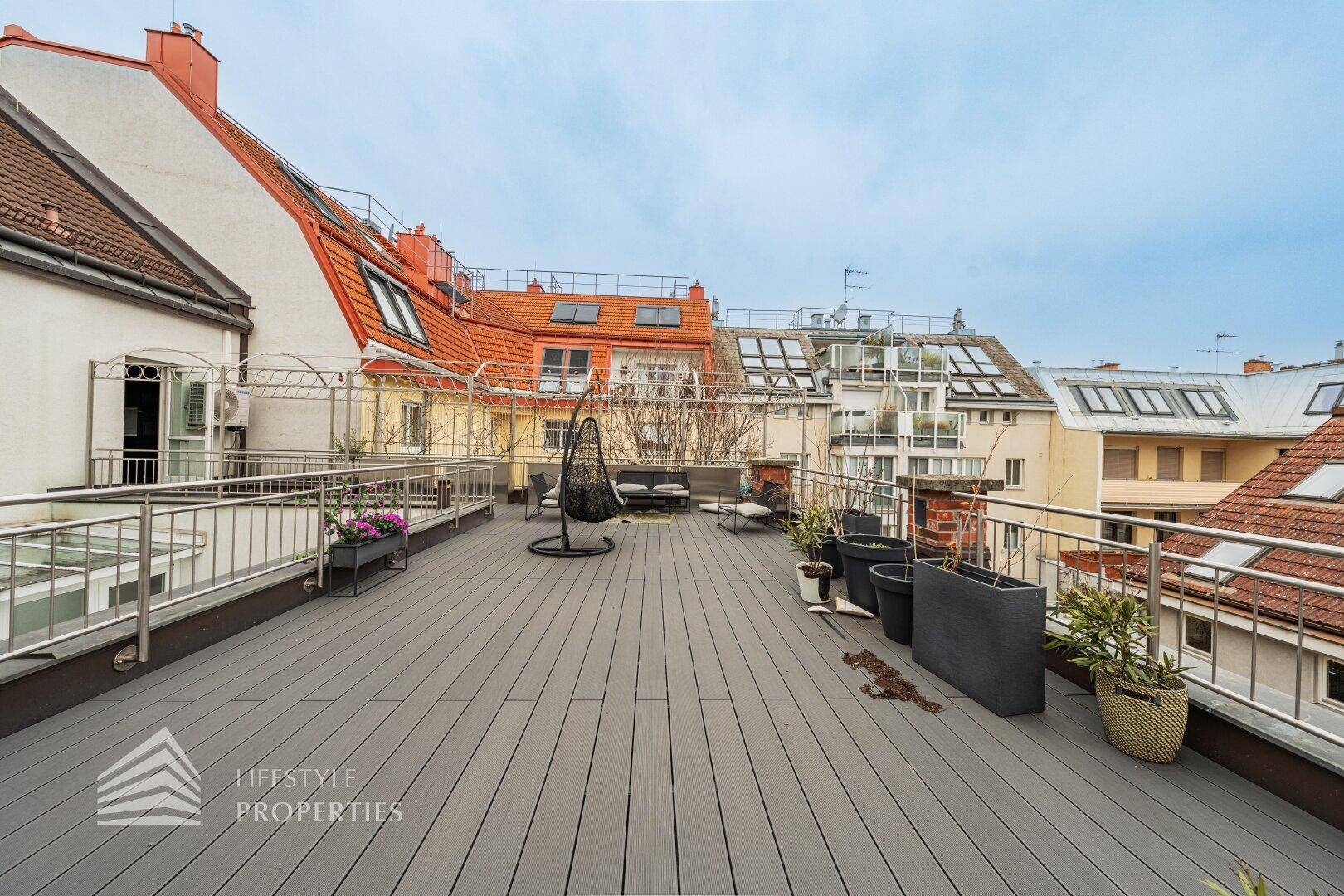 Weitläufige Dachterrasse mit Sitzgelegenheiten und Panoramablick über die Stadt.