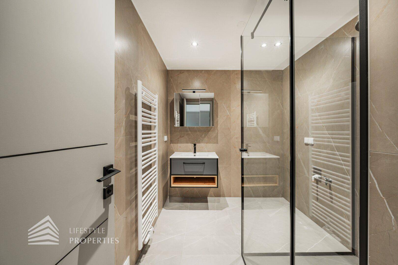 Stilvolles Badezimmer mit großer begehbarer Dusche und modernem Waschtisch.