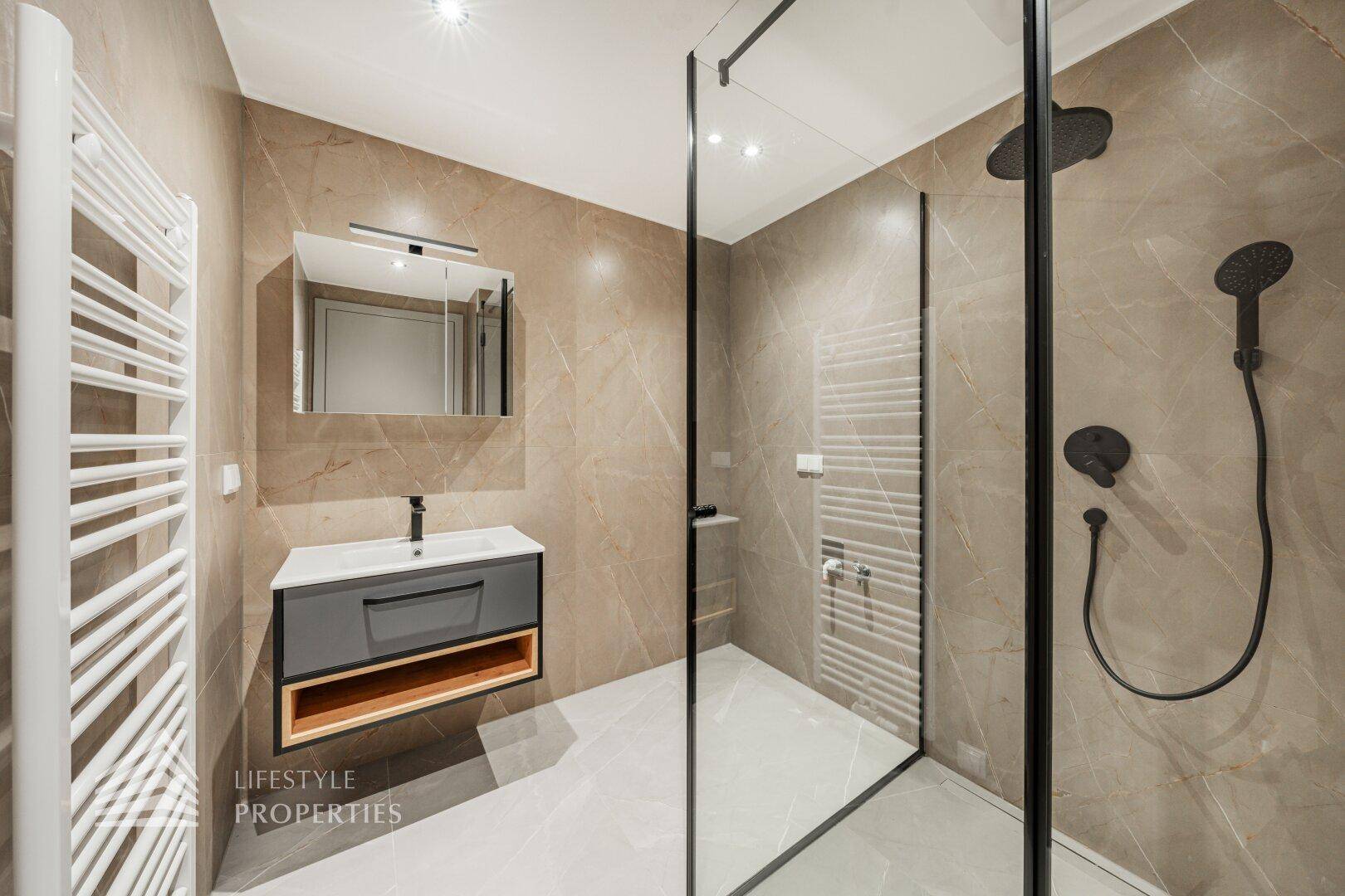 Modernes Badezimmer mit begehbarer Dusche, eleganten Fliesen und beheiztem Handtuchhalter.