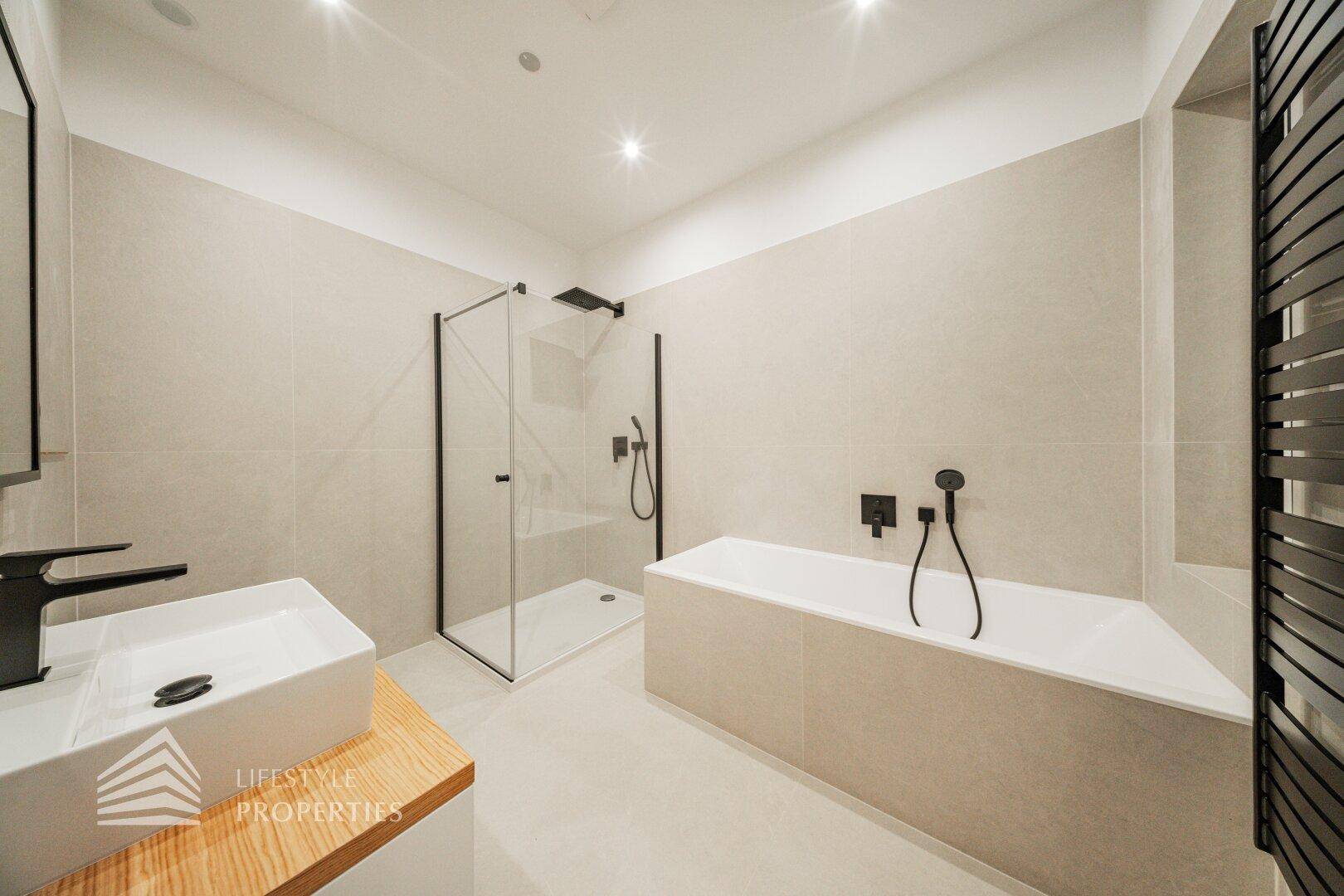Elegantes Badezimmer mit Badewanne, ebenerdiger Dusche und modernem Design.