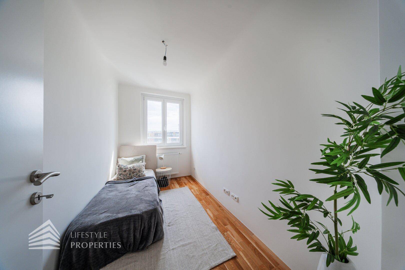 Gemütliches Schlafzimmer mit Einzelbett, Holzboden und Fenster.