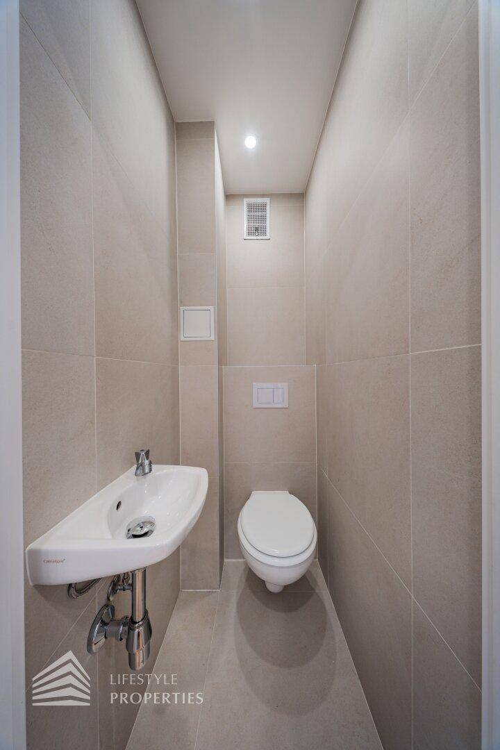 Modernes Gäste-WC mit Wand-WC und kleinem Waschbecken.