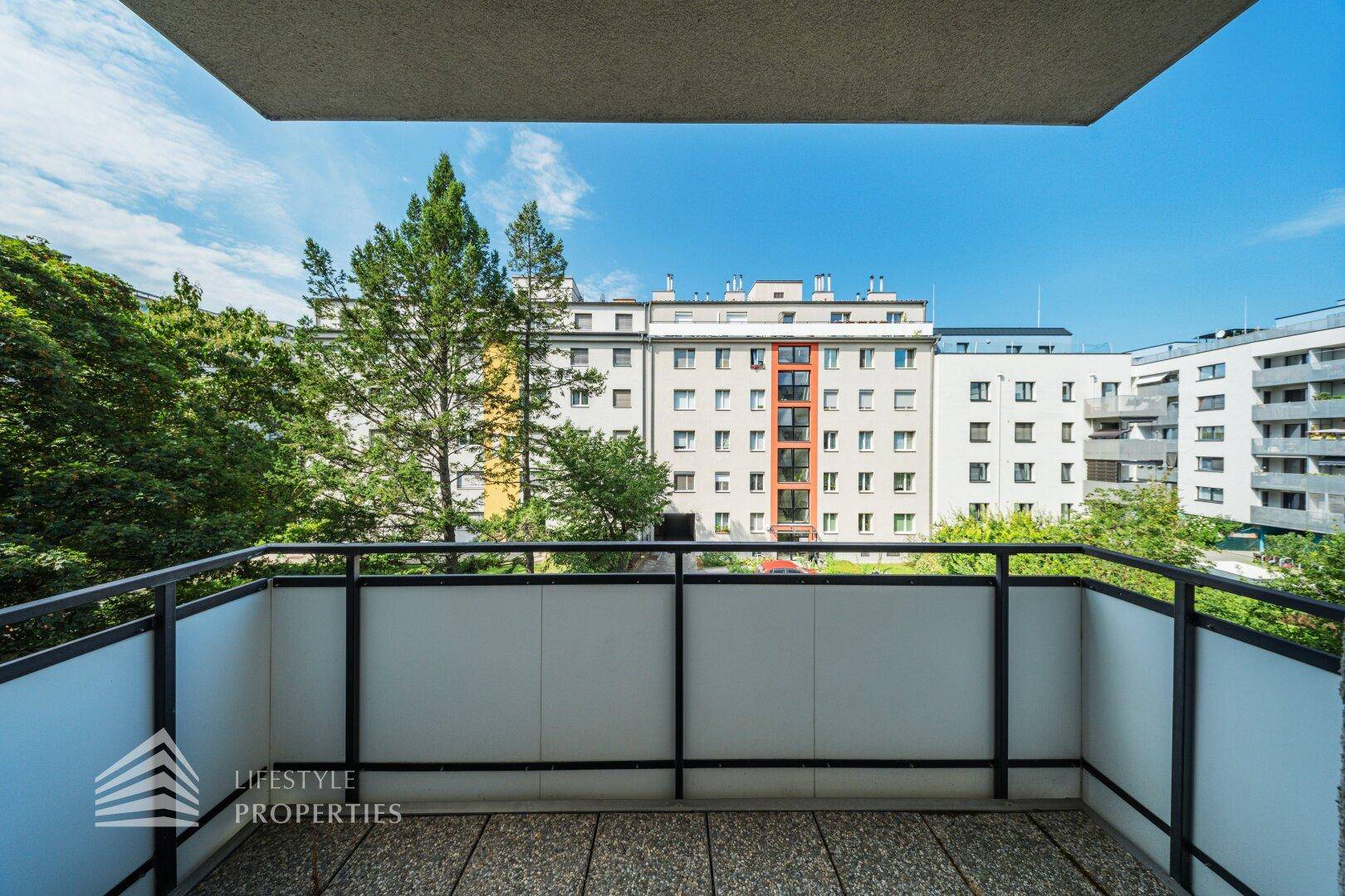 Geräumiger Balkon mit Blick auf die umliegenden Gebäude und Grünflächen.