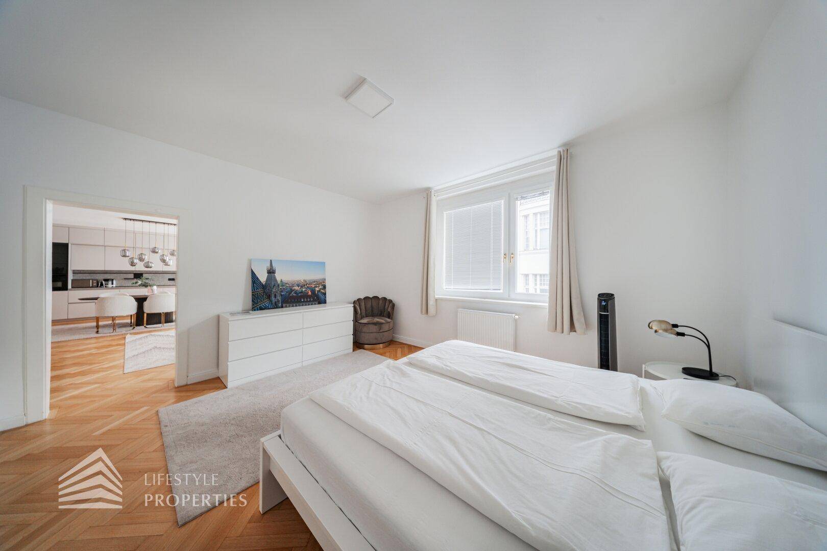 Schlafzimmer mit Doppelbett und Zugang zum offenen Wohnbereich.