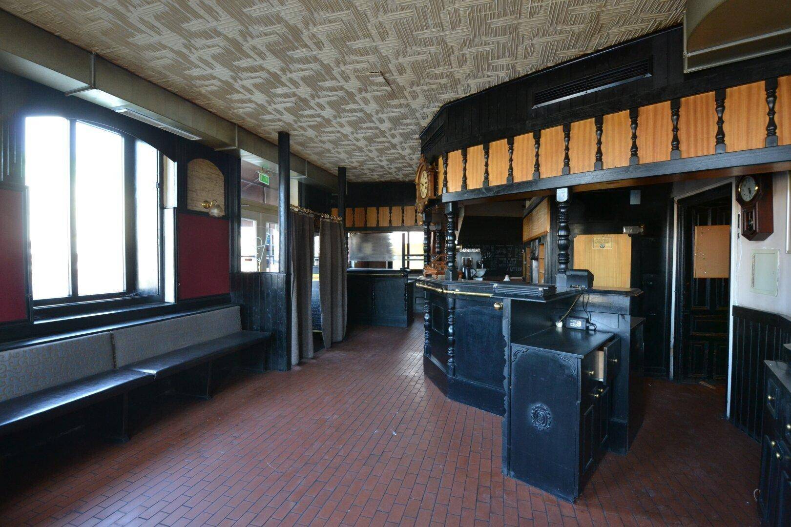 Blick auf den Barbereich und die Fensterfront mit Sitzgelegenheiten in diesem traditionellen Restaurant.