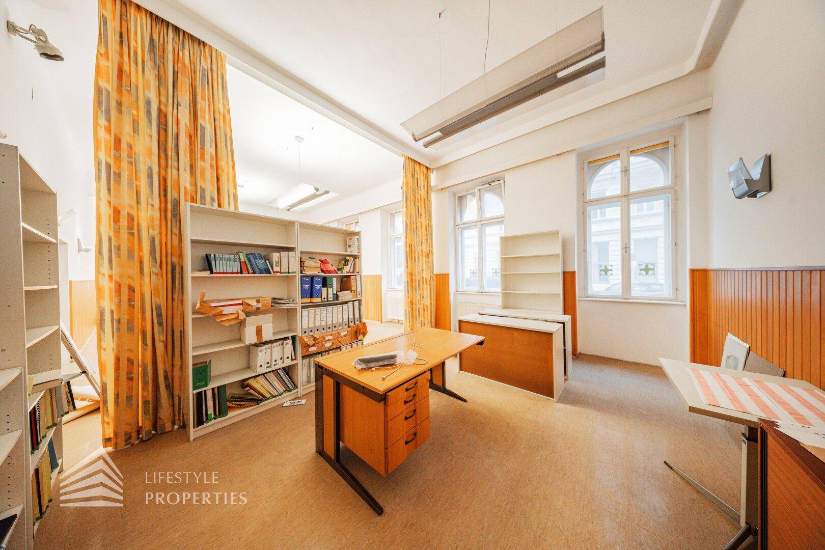 Helles Büro mit vielen Regalen, Schreibtischen und dekorativen Vorhängen, bietet viel Stauraum.