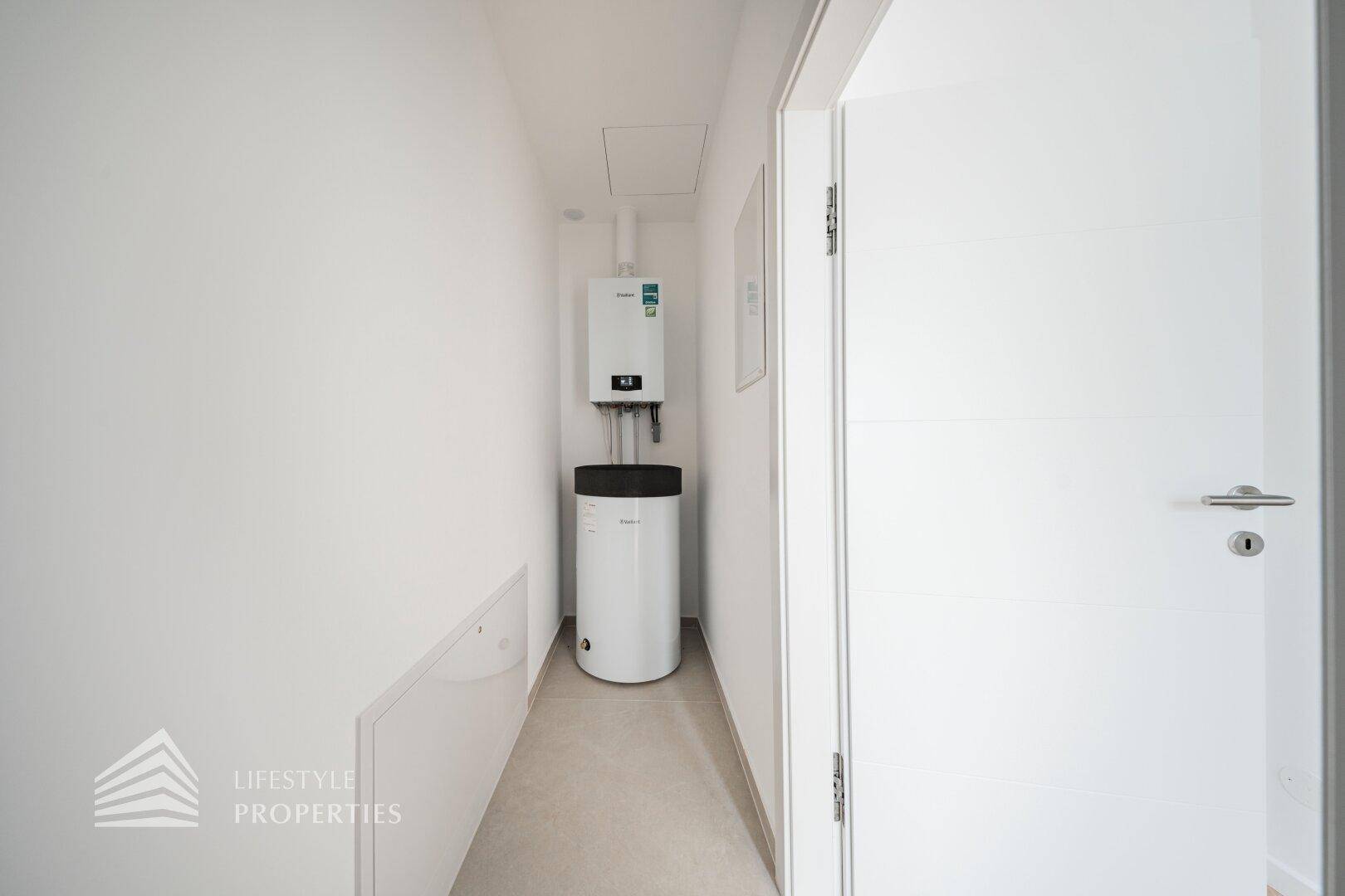Kleiner Hauswirtschaftsraum mit Warmwasserbereiter und Heizungsanlage, ideal für Technik.